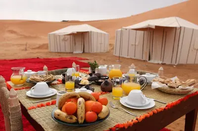 a table with food and drinks in the desert at merzouga asamer in Merzouga