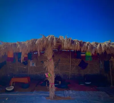 a large straw roofed tent with a rainbow at Azadic luxury tents in Merzouga