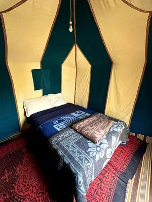 a bedroom with a bed in a tent at Sahara Joy Camp in Merzouga