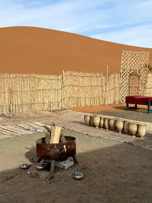a desert with a wooden fence and a red bench at Sahara Joy Camp in Merzouga