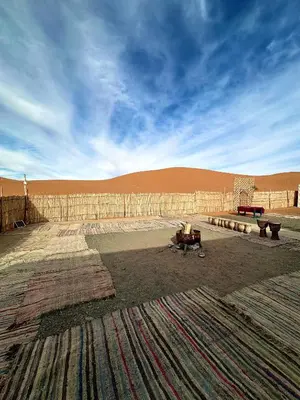 a room with a couch and a table in the desert at Sahara Joy Camp in Merzouga