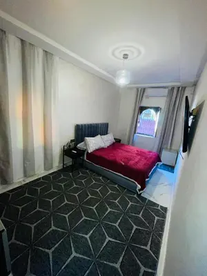 a bedroom with a red bed and a window at dar lmrrakchi in Oulad Akkou