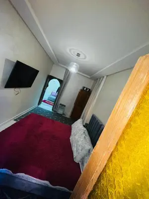 a small room with a bed and a flat screen tv at dar lmrrakchi in Oulad Akkou