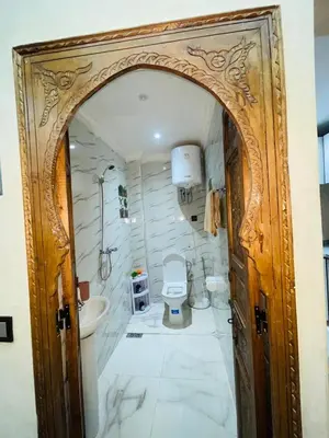 an entrance to a bathroom with a toilet and a sink at dar lmrrakchi in Oulad Akkou