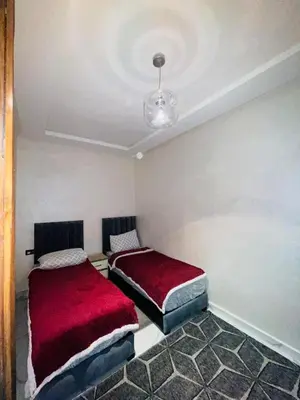 a bedroom with two beds with red covers at dar lmrrakchi in Oulad Akkou