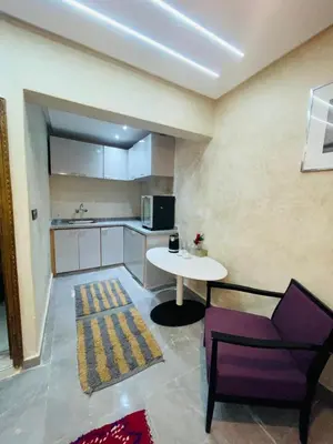 a kitchen with a table and a chair in a room at dar lmrrakchi in Oulad Akkou