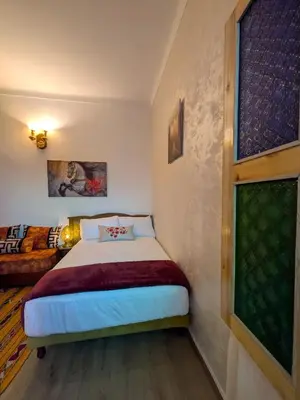 a small bedroom with a bed and a couch at Apartment Amoud with a panoramic view in Fès