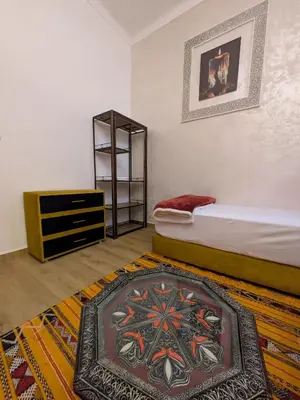 a bedroom with a bed and a dresser and a rug at Apartment Amoud with a panoramic view in Fès