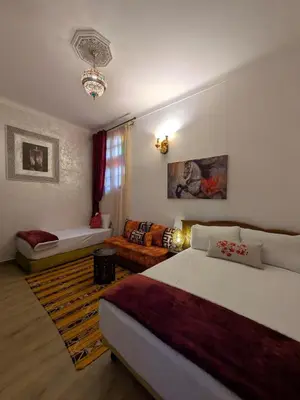 a bedroom with a bed and a living room at Apartment Amoud with a panoramic view in Fès
