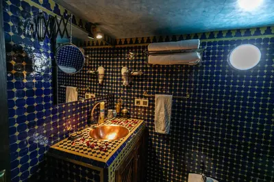 a bathroom with a copper sink and blue tiles at Dar Borj in Fès