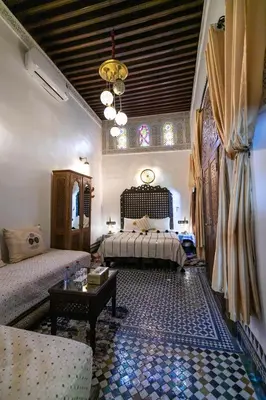a bedroom with two beds and a table in a room at Dar Borj in Fès