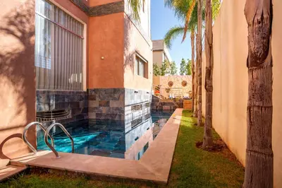 a house with a swimming pool next to a building at Villa Perle 6 Suites with Pool 5 Min from Center in Oulad Akkou