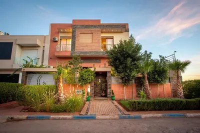 a brick house with trees in front of it at Villa Perle 6 Suites with Pool 5 Min from Center in Oulad Akkou