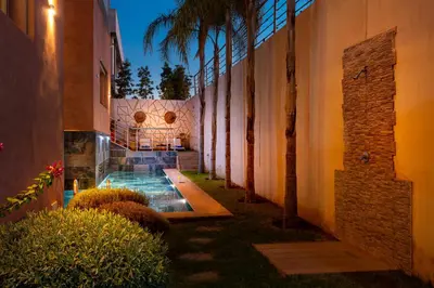 a courtyard with a swimming pool next to a building at Villa Perle 6 Suites with Pool 5 Min from Center in Oulad Akkou