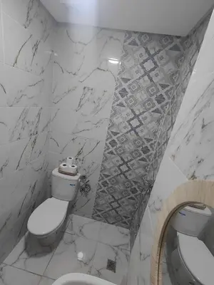 a white bathroom with a toilet and a sink at Cozy GenYcool Apartment Meknes Center in Meknès