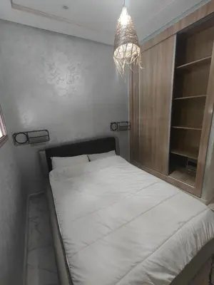 a bed in a bedroom with a chandelier at Cozy GenYcool Apartment Meknes Center in Meknès
