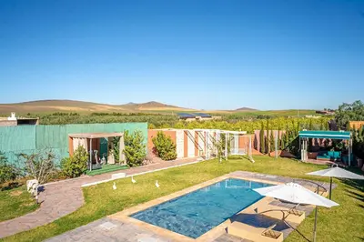 a backyard with a swimming pool and a house at Jnane Moulana Piscine Privée, Jardin & Vue Atlas