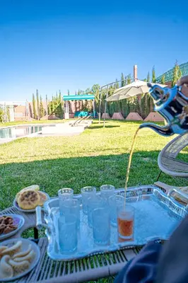 a picnic table with glasses of water and food at Jnane Moulana Piscine Privée, Jardin & Vue Atlas