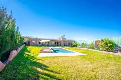a yard with a swimming pool and a house at Jnane Moulana Piscine Privée, Jardin & Vue Atlas