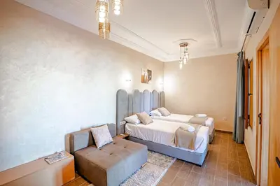 a bedroom with a bed and a chair and a couch at Jnane Moulana Piscine Privée, Jardin & Vue Atlas