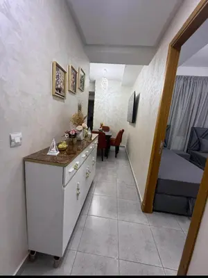 a corridor of a room with a bed and a table at Alyassamine in Taza