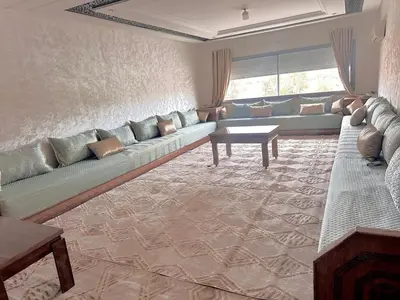 a living room with a long couch and a table at إقامة حسن in Fès