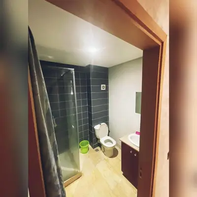 a bathroom with a toilet and a glass shower at إقامة حسن in Fès