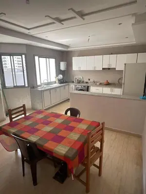 a kitchen with a table and a table and chairs at إقامة حسن in Fès