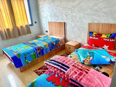 a bedroom with two twin beds with colorful sheets at إقامة حسن in Fès