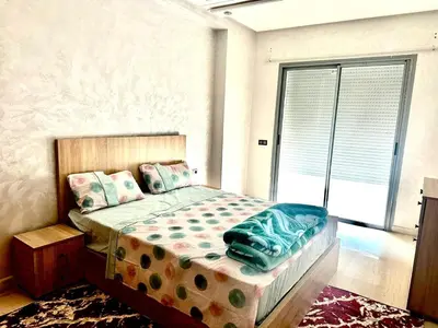 a bedroom with a bed and a large window at إقامة حسن in Fès
