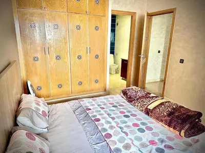 a bedroom with a bed with a large mirror at إقامة حسن in Fès