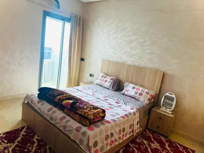 a bedroom with a large bed with a window at إقامة حسن in Fès