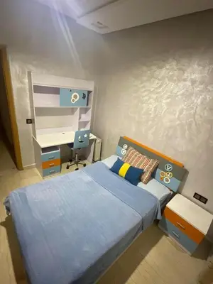 a small bedroom with a bed and a desk at إقامة حسن in Fès