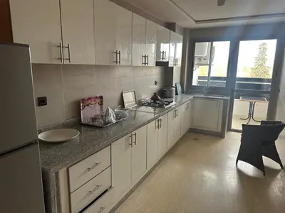 a kitchen with white cabinets and a counter top at إقامة حسن in Fès