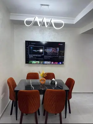 a dining room with a table with chairs and a tv at Alyassamine Taza in Settat