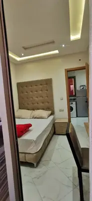 a bedroom with a bed and a chair in it at Idrissi appartement in Fès