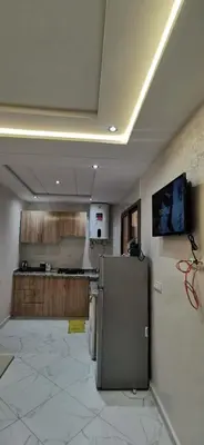 a kitchen with a refrigerator in the middle of a room at Idrissi appartement in Fès