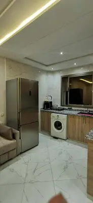 a kitchen with a refrigerator and a stove at Idrissi appartement in Fès