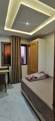 a bedroom with a bed and a desk in a room at Idrissi appartement in Fès
