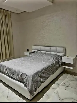 a bedroom with a large bed and two tables at Massira 2 in Taza