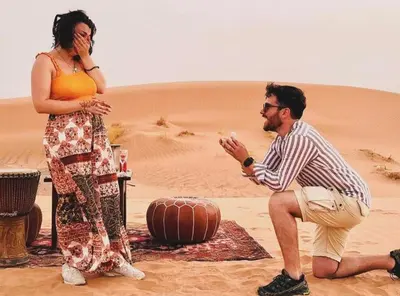 a man and a woman sitting in the desert at Sahara Luxury Camp in Merzouga