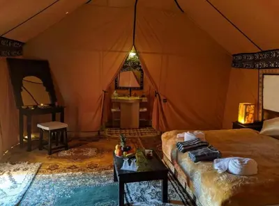 a bedroom with a bed in a tent at Sahara Luxury Camp in Merzouga