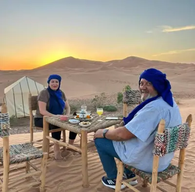 two women sitting at a table in the desert at Sahara Luxury Camp in Merzouga
