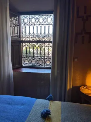 a bedroom with a window and a bed with blue sheets at Dar fatima in Midelt