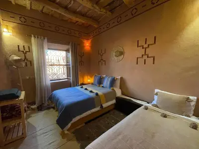 a bedroom with two beds and a window at Dar fatima in Midelt