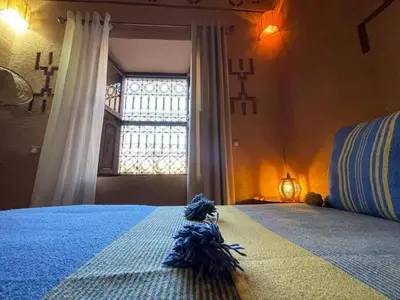 a bedroom with a blue bed with a window at Dar fatima in Midelt