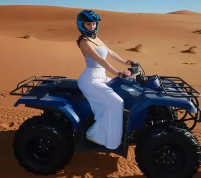 a woman riding a quad bike in the desert at Maria'S Luxury Camp in Merzouga