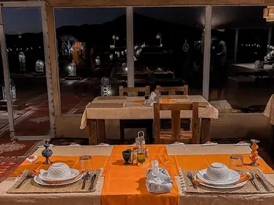 a table with plates and hats on top of it at Maria'S Luxury Camp in Merzouga