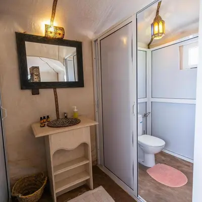 a bathroom with a toilet and a mirror at Dream Land Camp in Merzouga