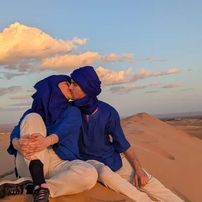 a man and woman kissing in the desert at Dream Land Camp in Merzouga